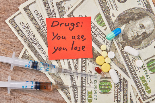 Amount of money, narcotics, message close up. Drugs: you use, you lose.