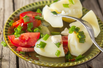 Boiled potato with tomatoes and green onions