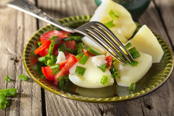 Boiled potato with tomatoes and green onions