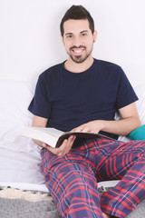 Man reading a book in bed.