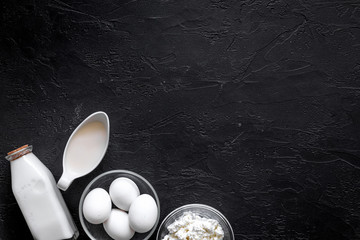 Obraz na płótnie Canvas Healthy food. Milk, cottage, eggs on black stone background top view copyspace