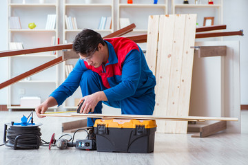 Young carpenter working with wooden planks