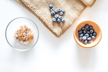 Making summer preserve. Blueberry and sugar on white background top view copyspace