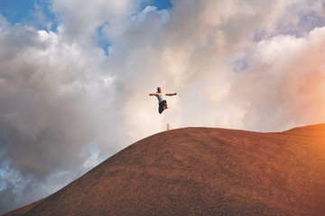 Strong and brave athlete extreme jumps and runs through the hills on outdoor