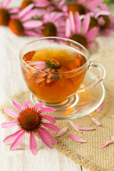 Cup of echinacea tea on white wooden table