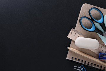 School supplies on a black board with space for text. View from above