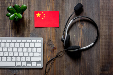 Self-development. Learning chinese online. Headphones and keyboard on wooden table background top view