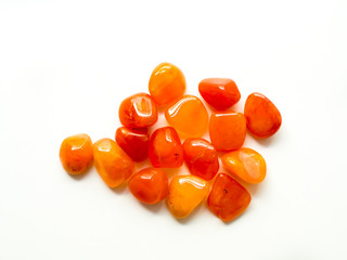 Tumbled carnelian stones on white background for crystal therapy treatments and reiki
