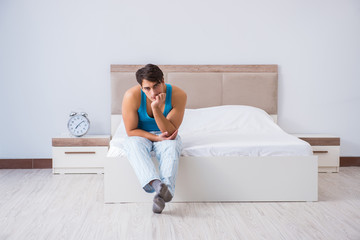 Young man waking up in bed