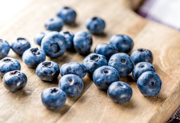 Freshly blueberries on wooden rustic wooden table. Juicy and fresh blueberries with green leaves. Bilberry on wooden background. Blueberry antioxidant. Concept for healthy eating and nutrition.