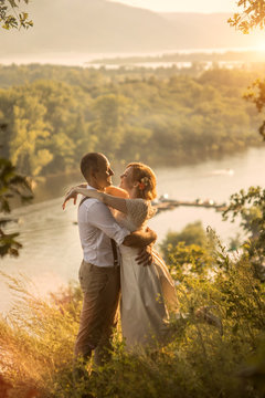 Attractive couple enjoying romantic sunset on the top of the hill.