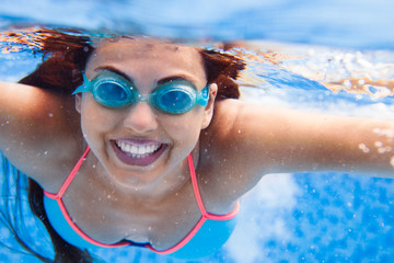 Portrait Young smiling woman swimming undewater in the swimming pool