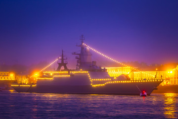 Fototapeta na wymiar Military ship docked in the city. Heavy fog. Ship in fog. Decorated with a garland of the ship.