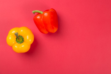 Top view of bright yellow and red bell peppers paprika on red background.