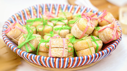 Small heads of French cheese, tied together, few pieces. Delicious gourmet gift, lying in a plate with colors of national flag, selective focus