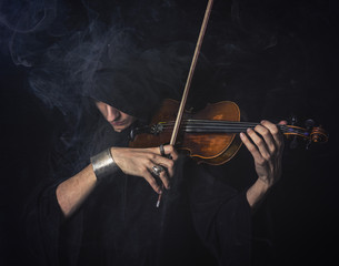 Dark phantom violin player with cloak and cape