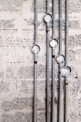 Metal electrical conduit on a bare breeze block wall at a building site.