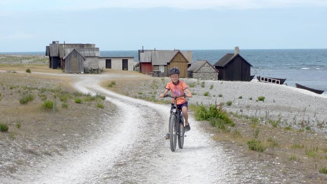 A boy on a bike by the fishing hamlet Helgumannen on the island Faro, Gotland, Sweden.