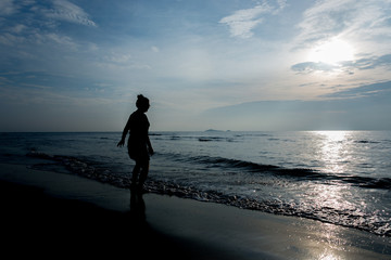 Naklejka premium Womand with Tropical sunset on the beach Prachuap Khiri Khan. Thailand