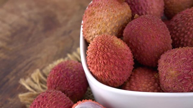 Portion of Lychees rotating on a wooden plate (not loopale; 4K)