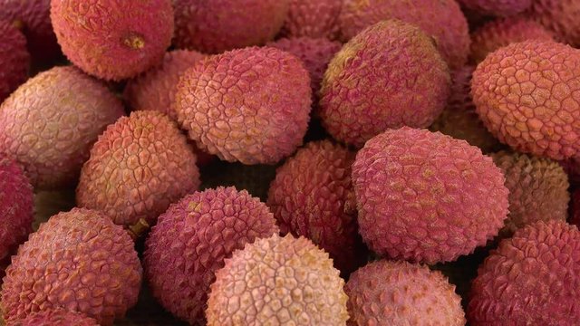 Portion of Lychees rotating on a wooden plate (not loopale; 4K)