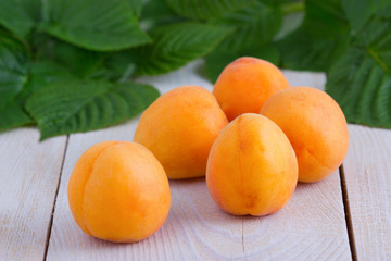 Спелые абрикосы на деревянном белом фоне