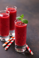 Strawberry smoothies in a glass on a dark  background. Selective focus. Copy space