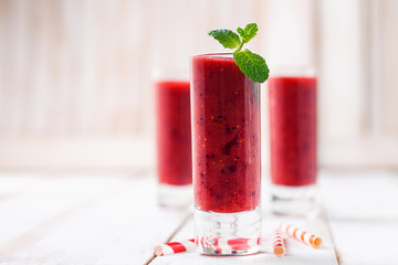Strawberry smoothies in a glass on a light wooden background. Selective focus. Copy space