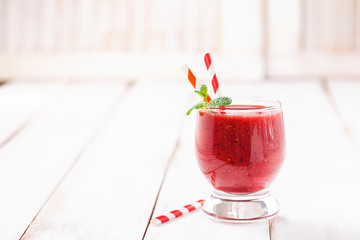 Strawberry smoothies in a glass on a light wooden background. Selective focus. Copy space