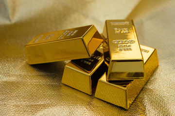 four pieces of gold bars on a golden background