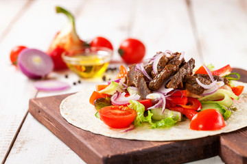 Tacos with Vegetables and Meat against a light wood Background. Selective Focus.