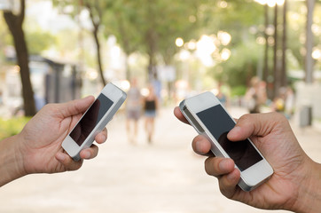 Two men holding mobile smart phone.