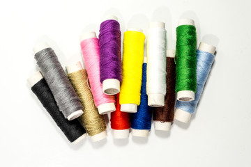 Colored thread coils on white background