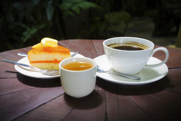 Coffee with orange cake on wood background