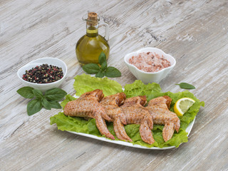 Chicken wings in marinade on a white plate. 