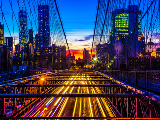 Manhattan skyline at sunset with the traffic on the brooklyn bridge