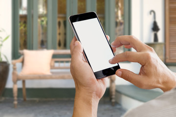 Man holding smartphone with blank screen in the front of blurred  background.