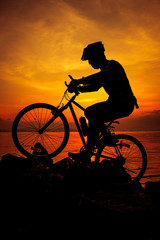 Fototapeta na wymiar Healthy lifestyle. Silhouette of bicyclist riding the bike at seaside. Outdoors.