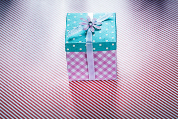 Gift box on striped fabric background top view celebrations conc
