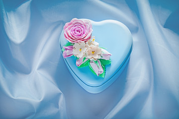 Heart-shaped present box on blue fabric background holidays conc