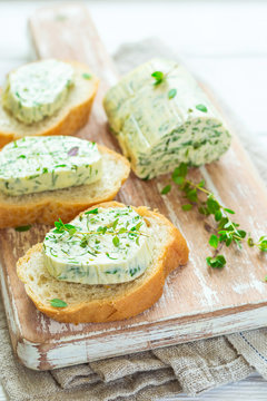Sandwiches with herbs butter On Cutting board on white wooden background