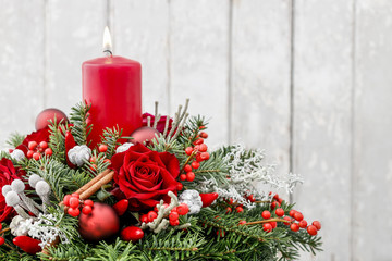 Christmas decoration with candle, red roses, fir, brunia and cinnamon sticks. © agneskantaruk