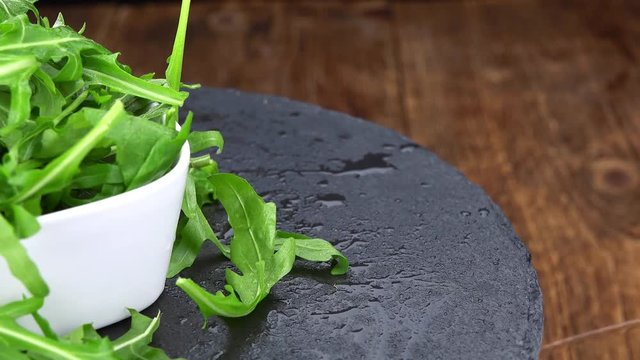 Fresh Arugula rotating on a wooden plate (not loopable; 4K)