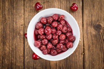 Portion of Canned Cherries on wooden background, selective focus