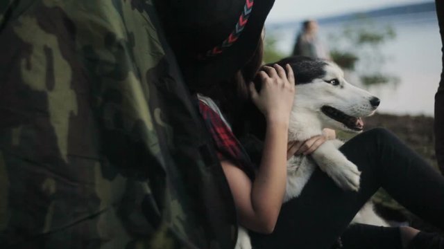Woman and Cute Dog Relaxing on Beach at Sunset
