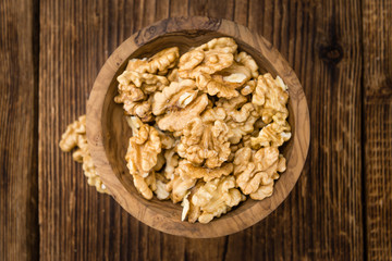 Portion of Cracked Walnuts on wooden background (selective focus)