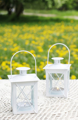 White iron lanterns on wooden table at summer party.