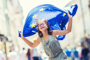 EU Flag. Cute happy girl with the flag of the European Union. Young teenage girl waving with the European Union flag in the city. - obrazy, fototapety, plakaty
