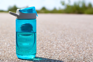 sports bottle of water stands on road