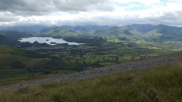 Touristic Cumbrian town in English Lake District and Derwentwater lake down in the valley. Scenic view from the path to Skiddaw mount.